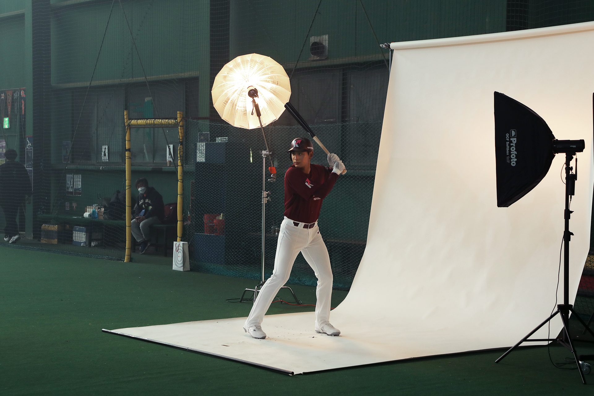 이정후 선수가 야구 배트를 들고 광고 지면 촬영하는 모습
